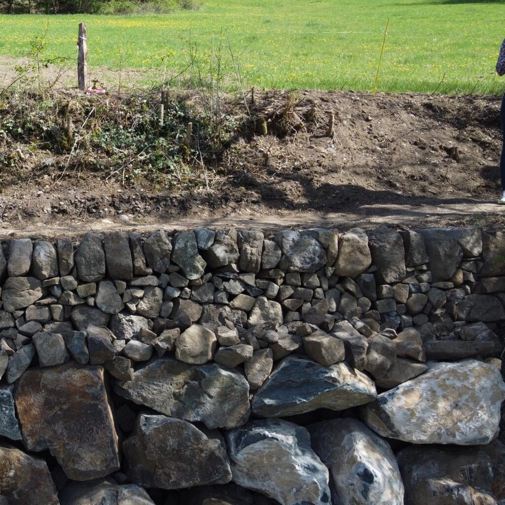 Mur en pierre sèche réalisé avec les pierres du site des Ravins de Corbœuf