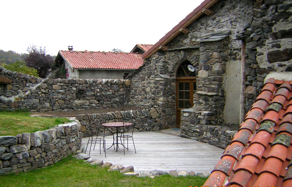 Terrasse en bois entourée de murets en pierre sèche à Retournac