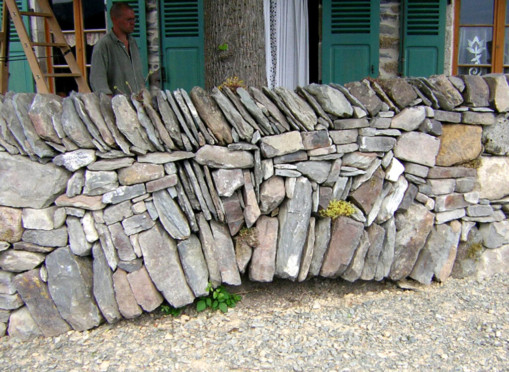 Petite voûte et couronnement sur chant dans un mur en pierre sèche à Retournac