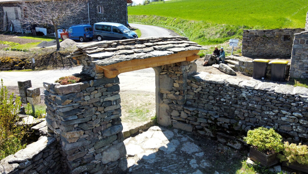 Porche traditionnel en pierre, bois et lauzes au Fayat à Rosières