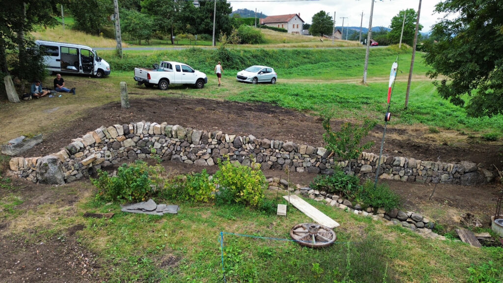 Mur de soutènement en pierre sèche dans un jardin à Saint-Étienne-Lardeyrol
