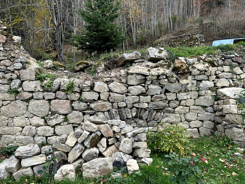 Ancien mur en pierre avant restauration aux Jardins Marcon