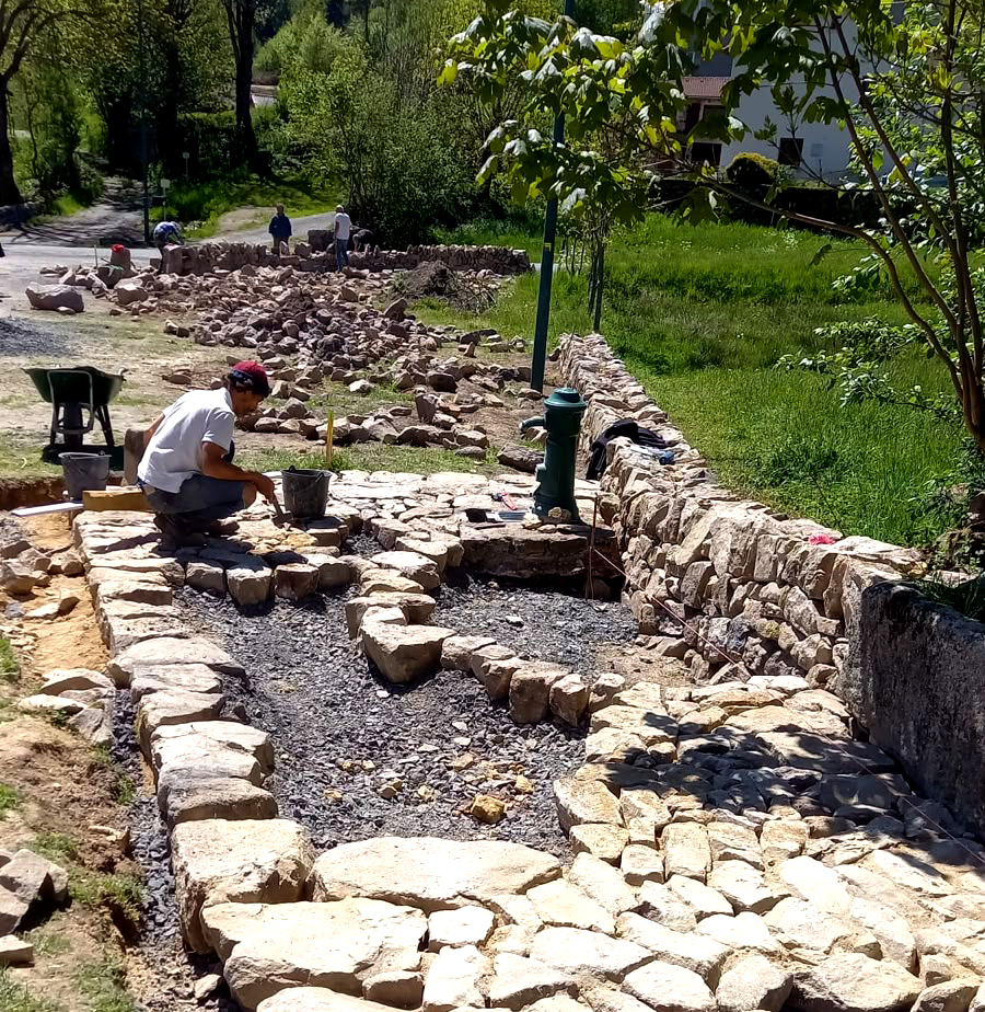 Murailler réalisant la calade autour du point d’eau à Saint-Vénérand