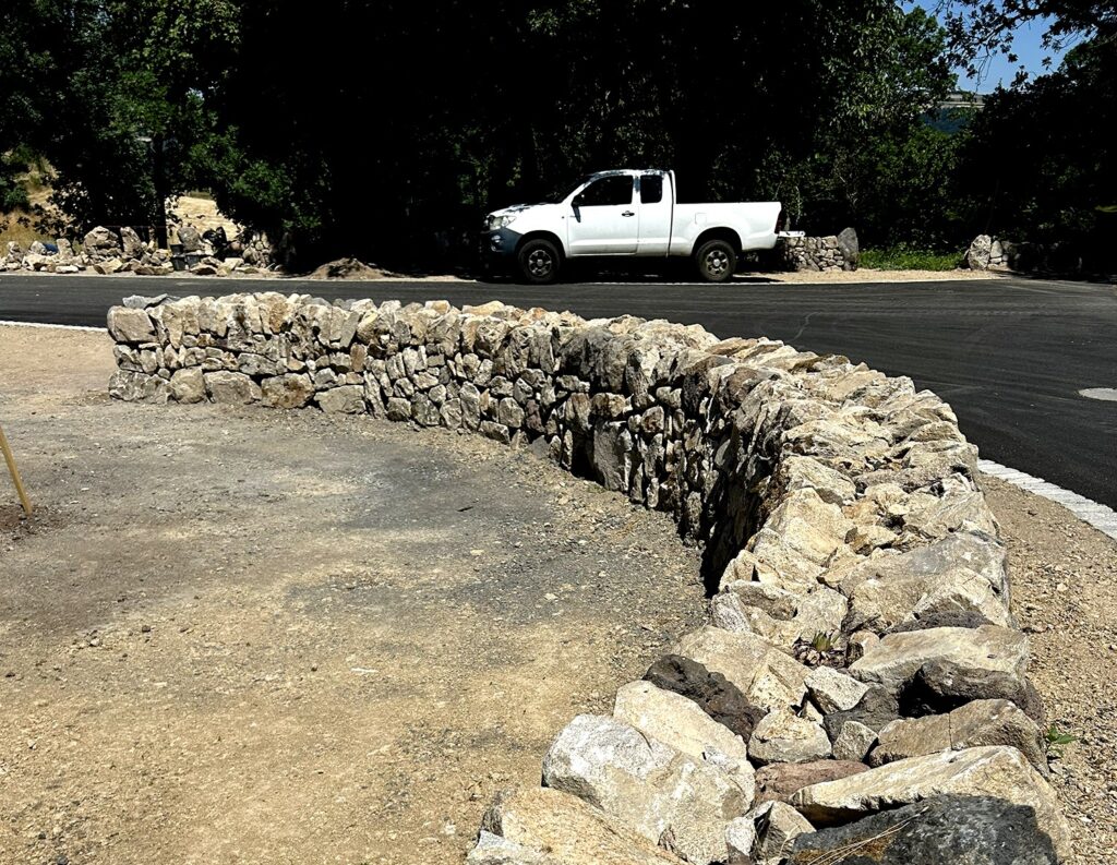Courbe d’un mur en pierre sèche avec couronnement clavé à Saint-Vénérand